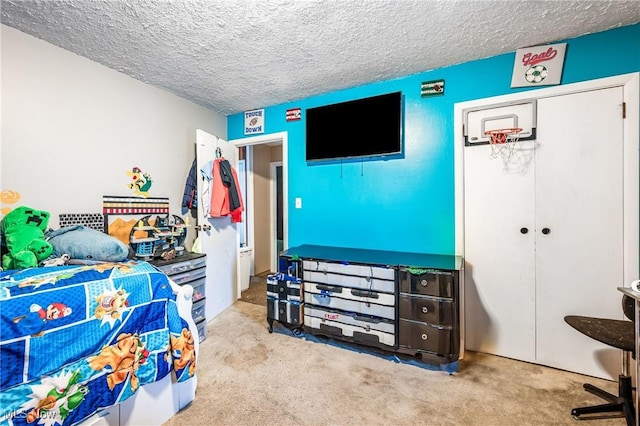 bedroom with light carpet, a textured ceiling, and a closet