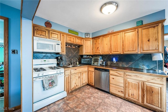 kitchen featuring white appliances, sink, light tile patterned floors, and tasteful backsplash