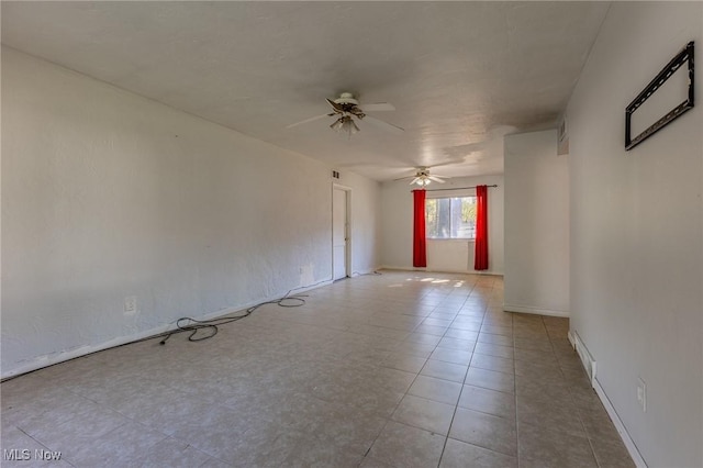 tiled spare room with ceiling fan