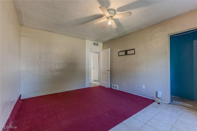 tiled empty room with ceiling fan