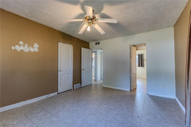 unfurnished bedroom featuring ceiling fan, tile patterned flooring, and a textured ceiling