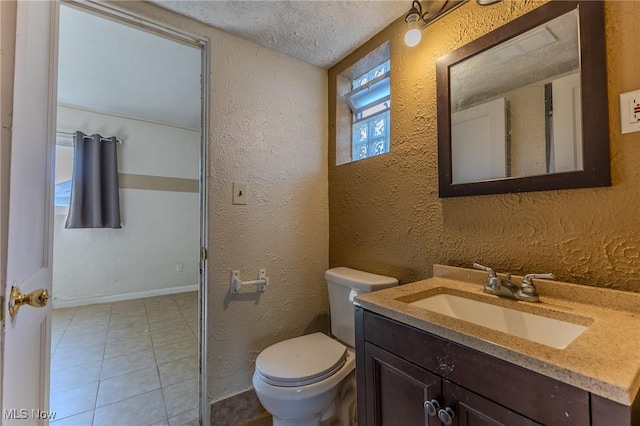 bathroom featuring tile patterned flooring, vanity, a textured ceiling, and toilet