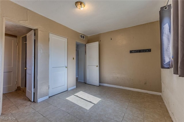 unfurnished bedroom featuring light tile patterned flooring