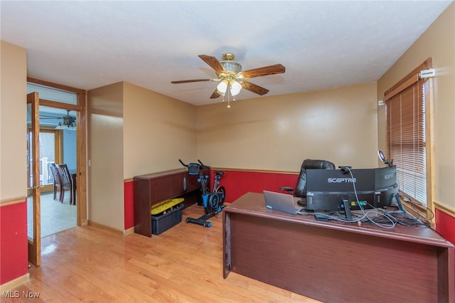 office area with light hardwood / wood-style floors, plenty of natural light, and ceiling fan