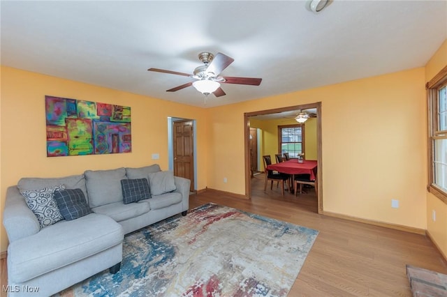 living room with light hardwood / wood-style flooring and ceiling fan