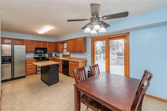 kitchen featuring french doors, ceiling fan, sink, black appliances, and a kitchen island