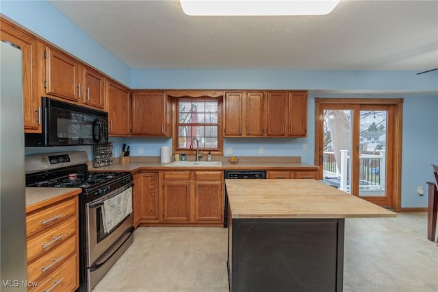 kitchen with sink, wooden counters, a textured ceiling, and appliances with stainless steel finishes