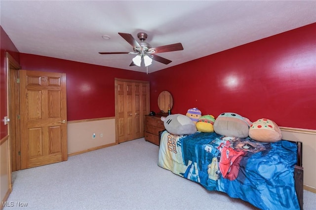 carpeted bedroom featuring ceiling fan and a closet