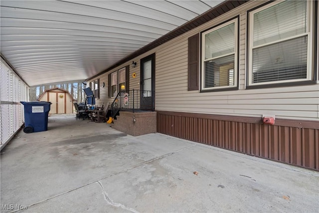 view of patio / terrace with a carport and a storage shed