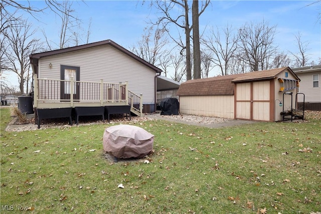 back of property featuring a lawn, a deck, and a storage unit