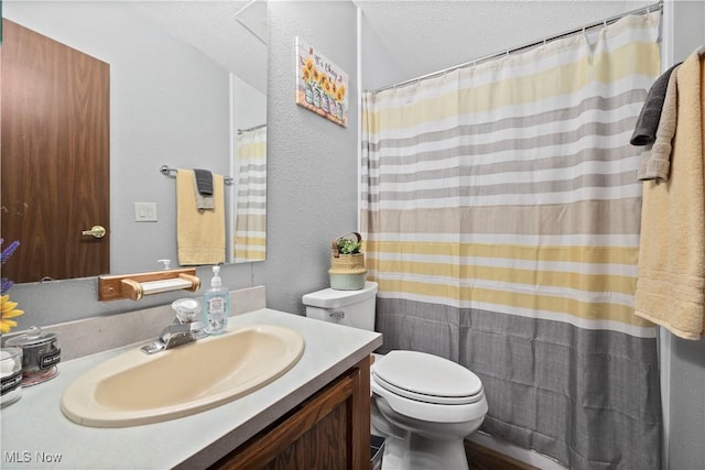 bathroom with vanity, a textured ceiling, and toilet