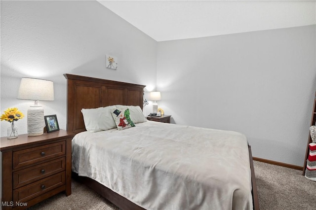 bedroom featuring light colored carpet and vaulted ceiling