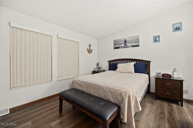 bedroom with dark hardwood / wood-style flooring and vaulted ceiling