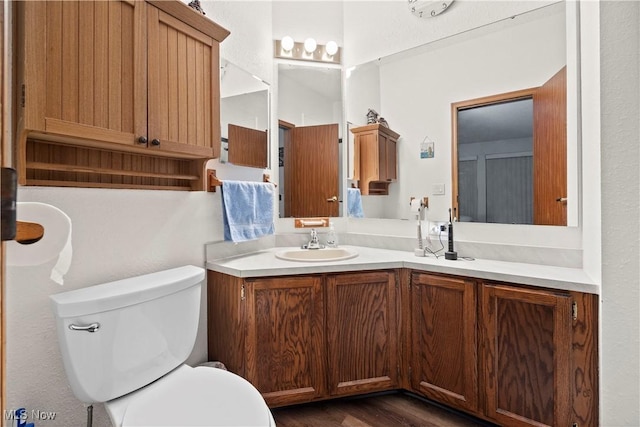 bathroom with vanity, toilet, and wood-type flooring