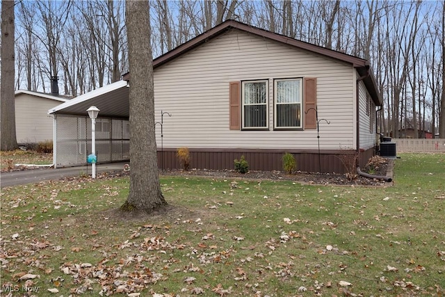 view of side of property with a yard, central AC unit, and a carport