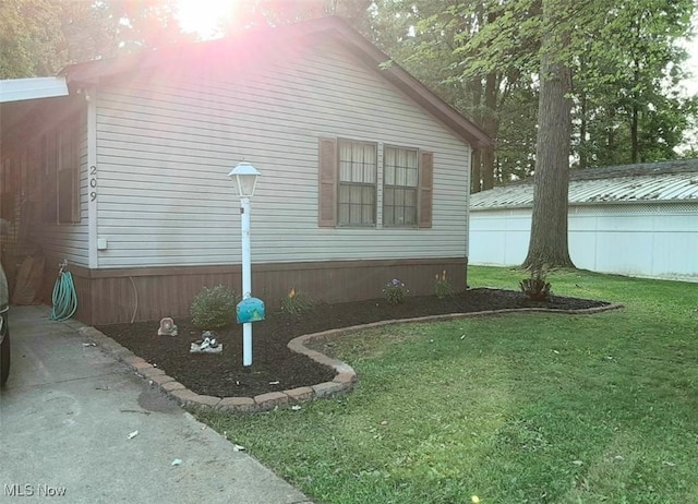 view of side of home with a yard