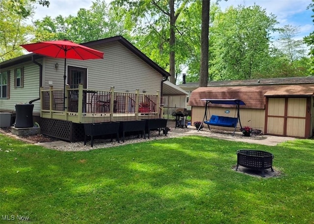 rear view of property featuring a lawn, a wooden deck, and a carport