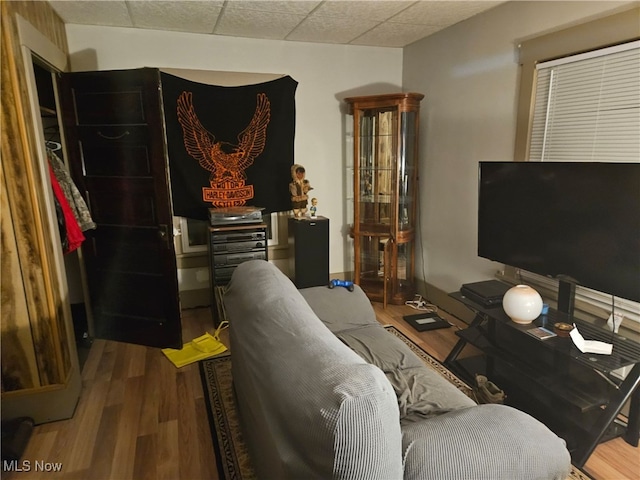 living room with hardwood / wood-style floors and a drop ceiling