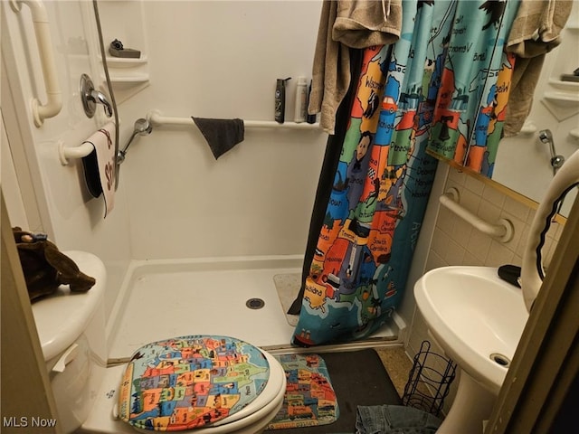 bathroom with curtained shower, toilet, and sink