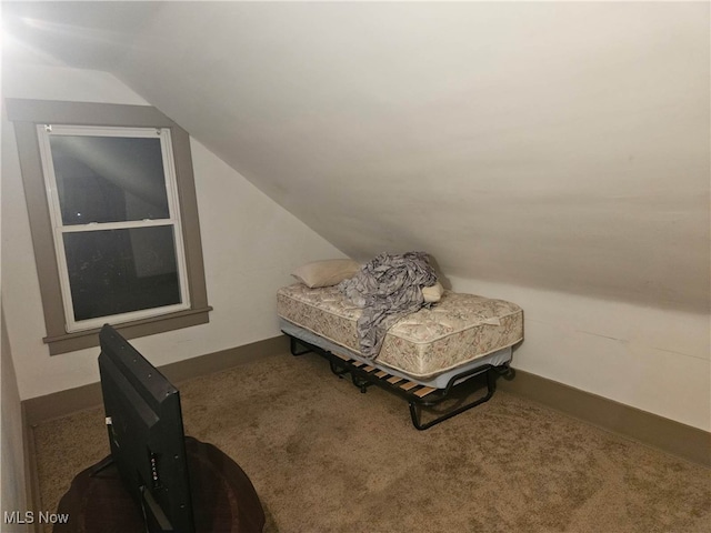 sitting room featuring dark colored carpet and lofted ceiling