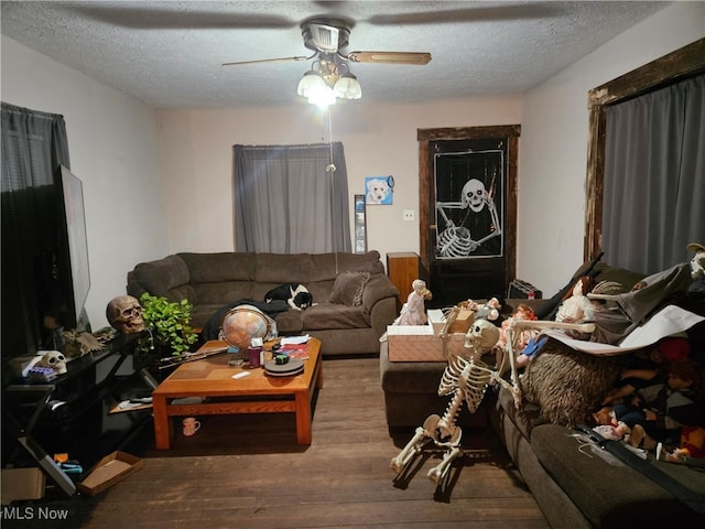 living room featuring hardwood / wood-style floors, ceiling fan, and a textured ceiling