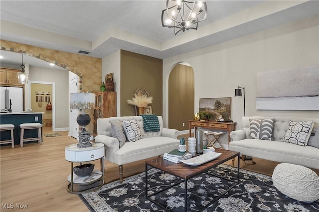 living room with hardwood / wood-style floors and a notable chandelier