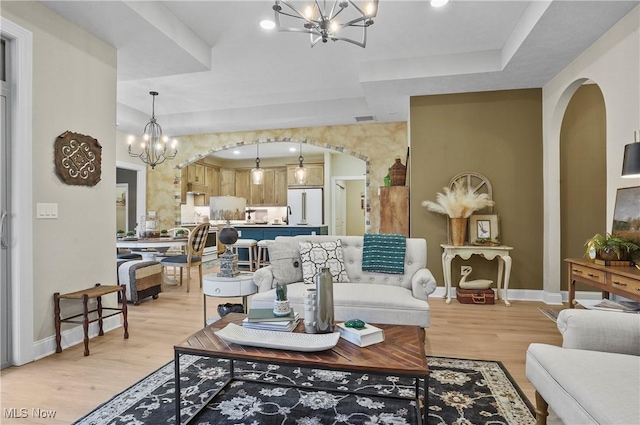 living room with a chandelier and light wood-type flooring