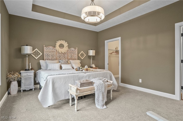 carpeted bedroom featuring a walk in closet and a closet