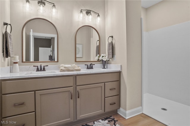 bathroom with walk in shower, vanity, and hardwood / wood-style flooring