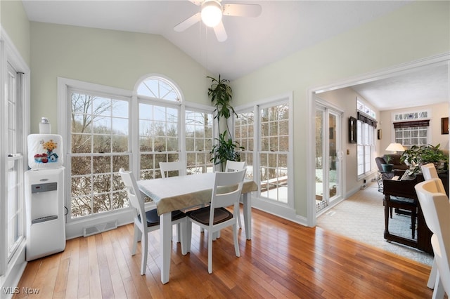 dining area featuring ceiling fan, wood-type flooring, and vaulted ceiling