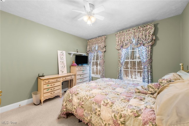 carpeted bedroom with ceiling fan and a textured ceiling