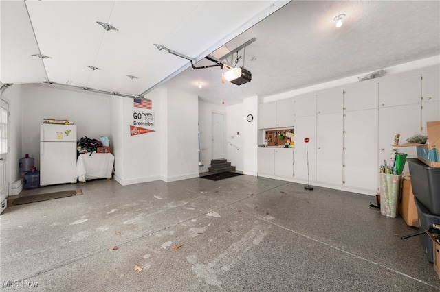 garage featuring white fridge and a garage door opener