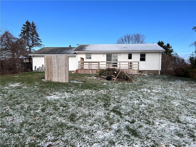 rear view of property featuring a deck and a lawn