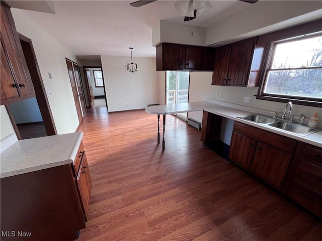 kitchen with pendant lighting, wood-type flooring, sink, and a wealth of natural light