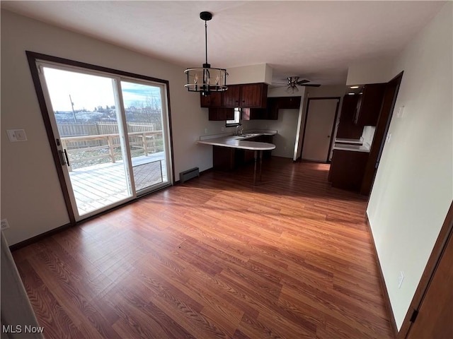 kitchen with sink, light hardwood / wood-style flooring, dark brown cabinets, a baseboard radiator, and kitchen peninsula