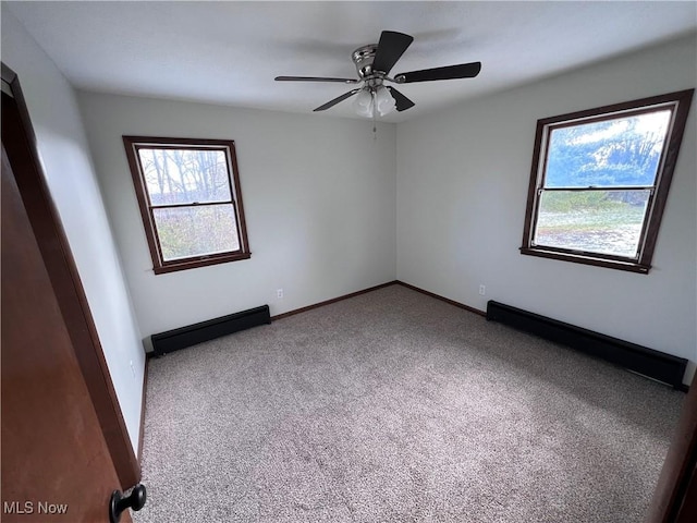 carpeted empty room with ceiling fan and baseboard heating