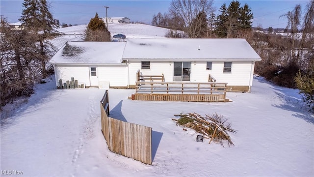 snow covered house with a wooden deck