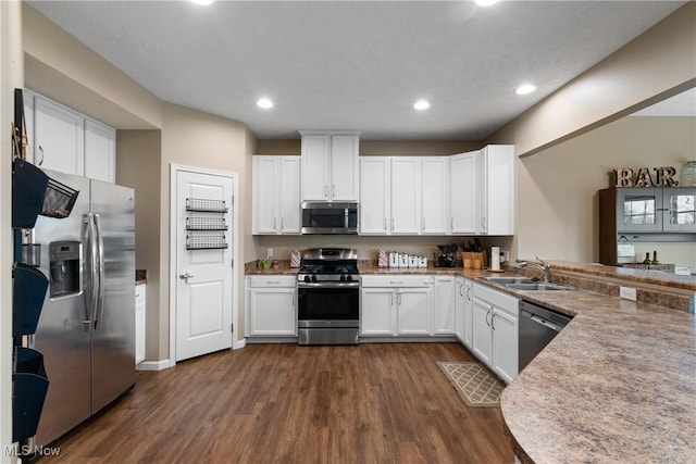 kitchen featuring stainless steel appliances, white cabinetry, and sink