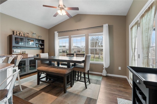 dining room featuring ceiling fan, dark hardwood / wood-style flooring, and lofted ceiling