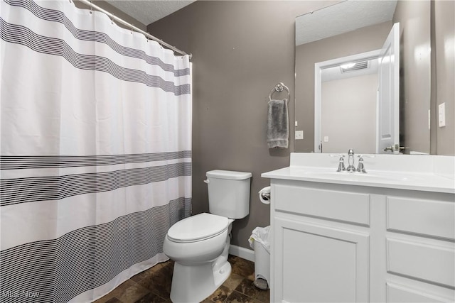 bathroom featuring a textured ceiling, vanity, and toilet