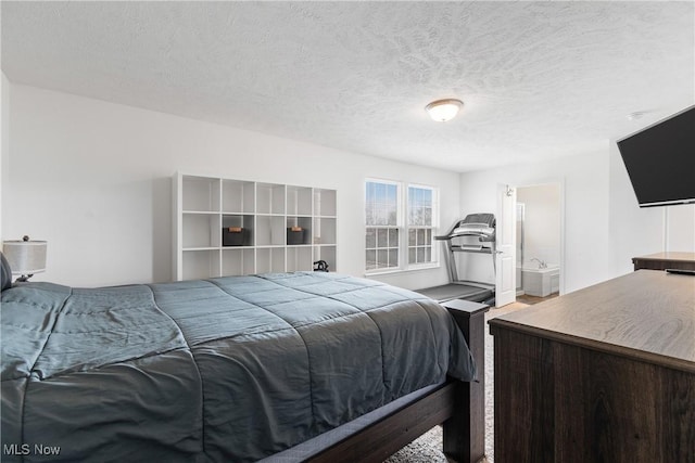 bedroom with a textured ceiling and ensuite bath