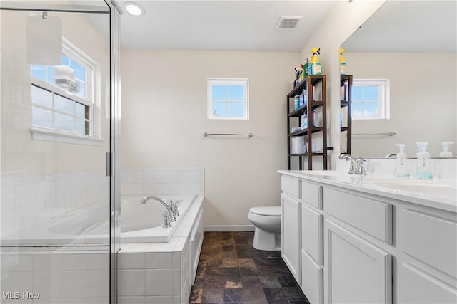 bathroom with vanity, toilet, and tiled tub