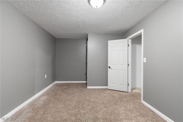 unfurnished bedroom with carpet and a textured ceiling