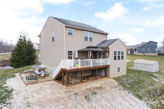 back of house with a wooden deck and a patio area