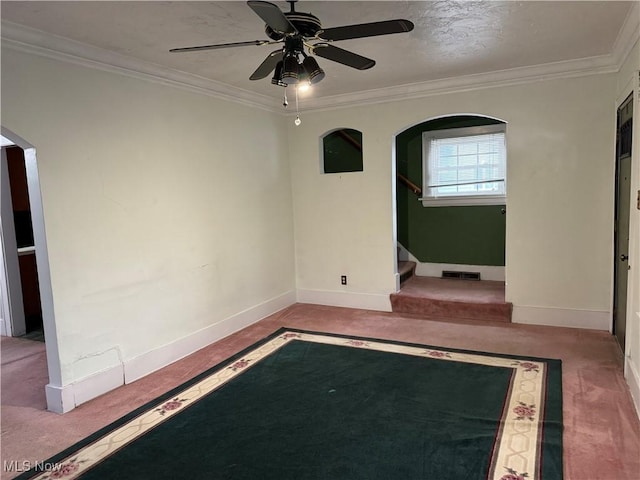 carpeted spare room featuring a textured ceiling, ceiling fan, and ornamental molding