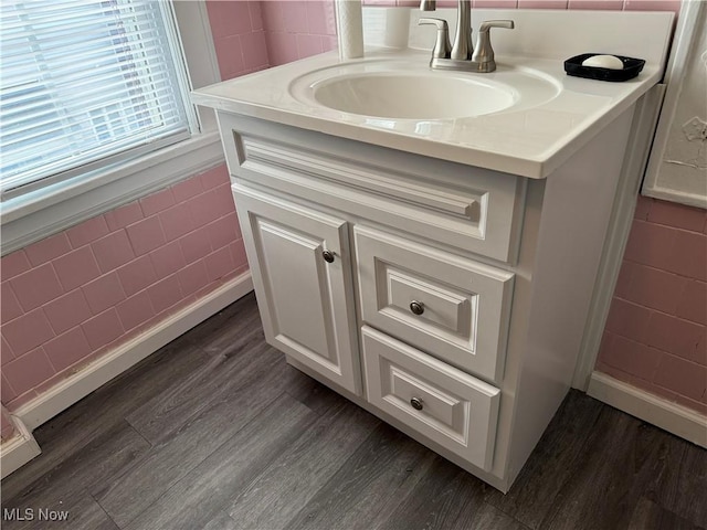 bathroom featuring hardwood / wood-style flooring, vanity, and tile walls