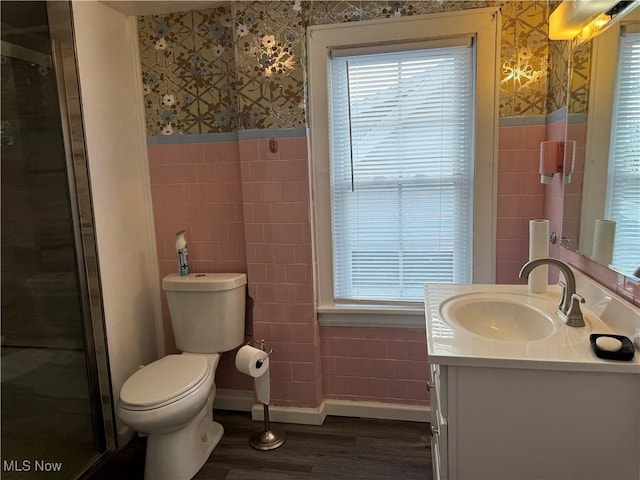 bathroom with hardwood / wood-style floors, vanity, toilet, and tile walls