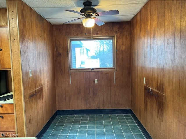 unfurnished room with wooden walls and ceiling fan