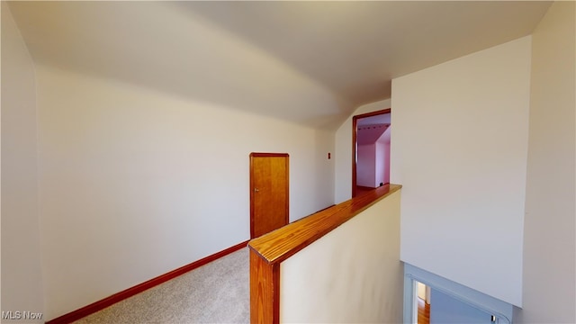 corridor with carpet and vaulted ceiling