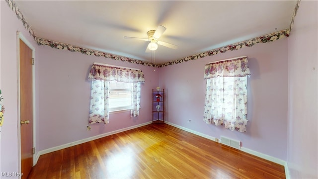 empty room featuring ceiling fan and hardwood / wood-style floors